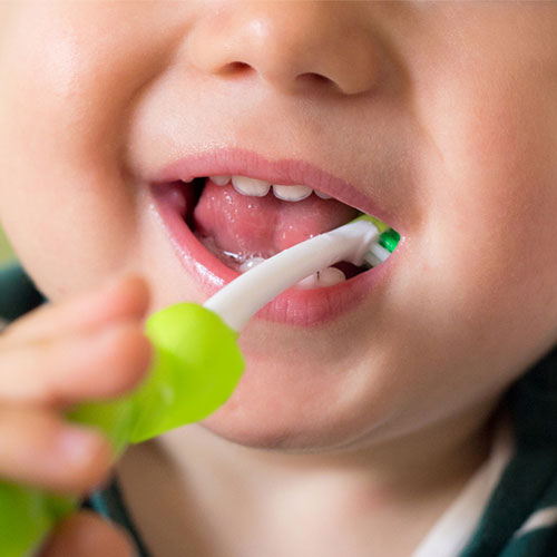 close up of kid brushing their teeth